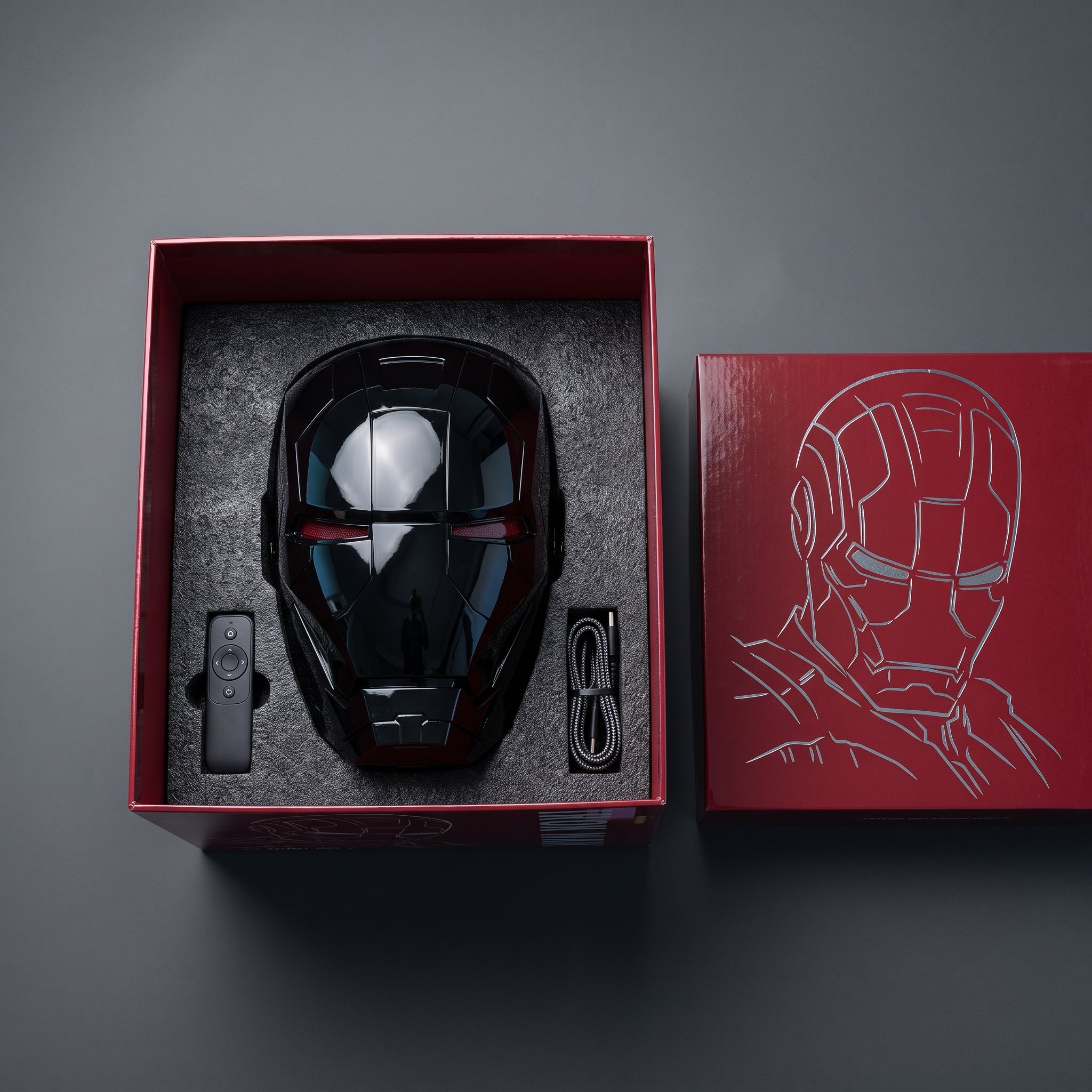 Gloss black Mark V helmet in its open box with remote control and USB charging cable