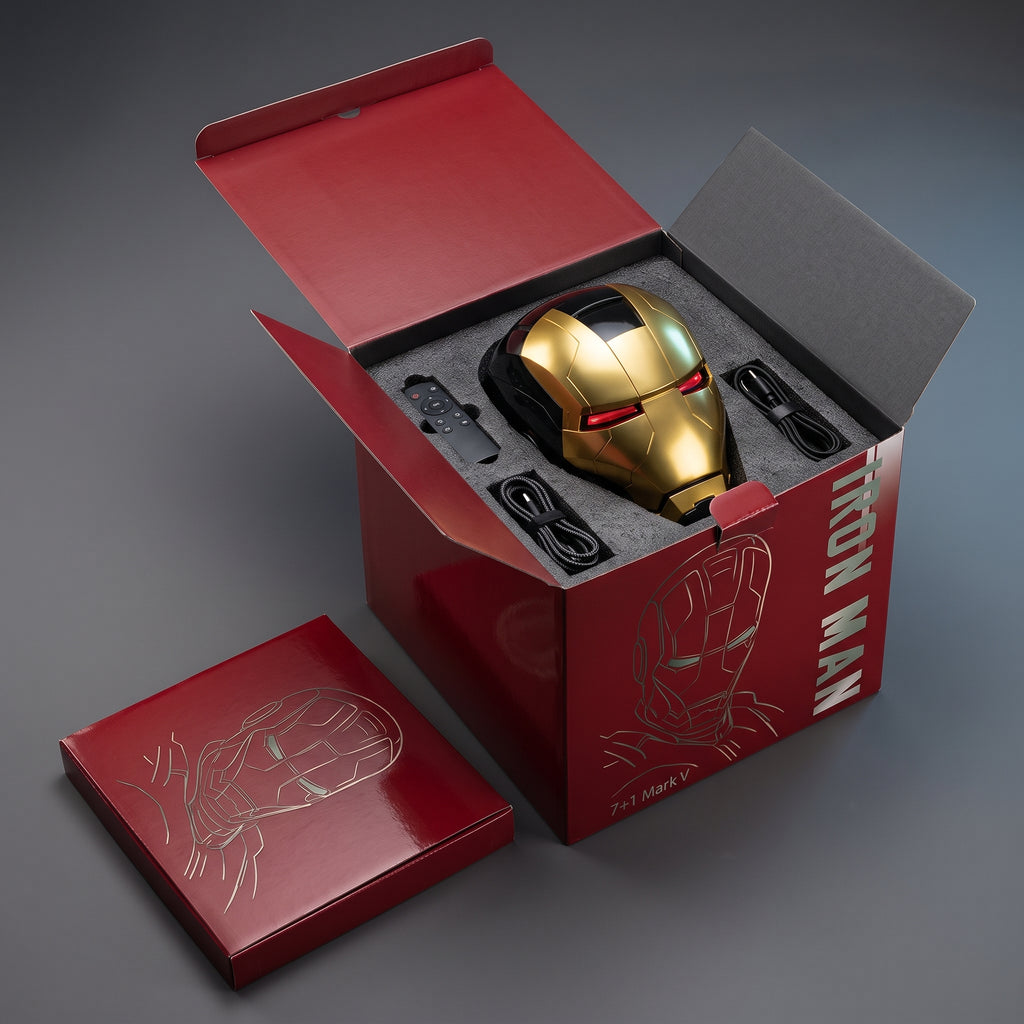 Black and gold Mark V helmet in its open box with remote control and USB charging cable