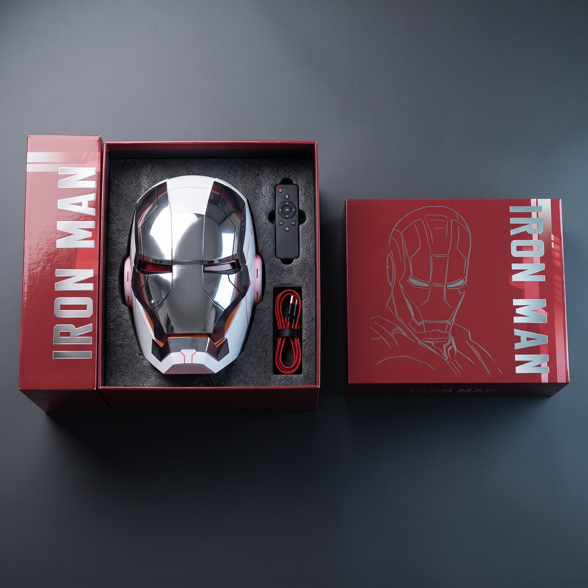 White and silver Mark V helmet in its open box with remote control and USB charging cable