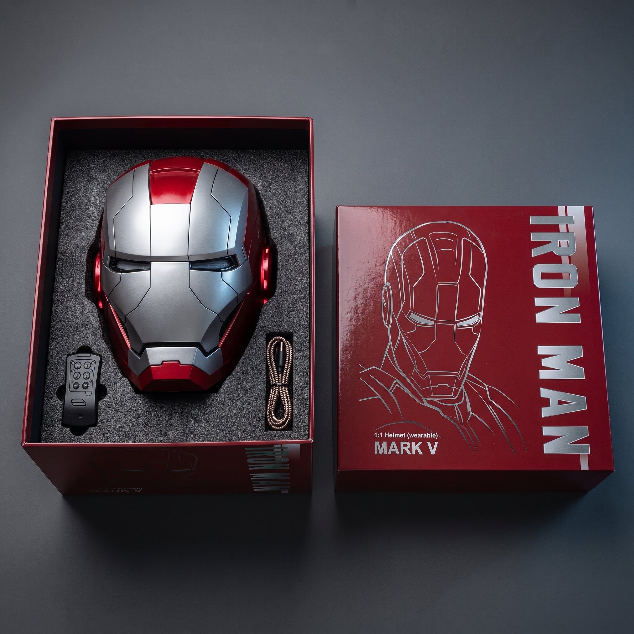 Matte silver and red Mark V helmet in its open box with remote and USB charging cable