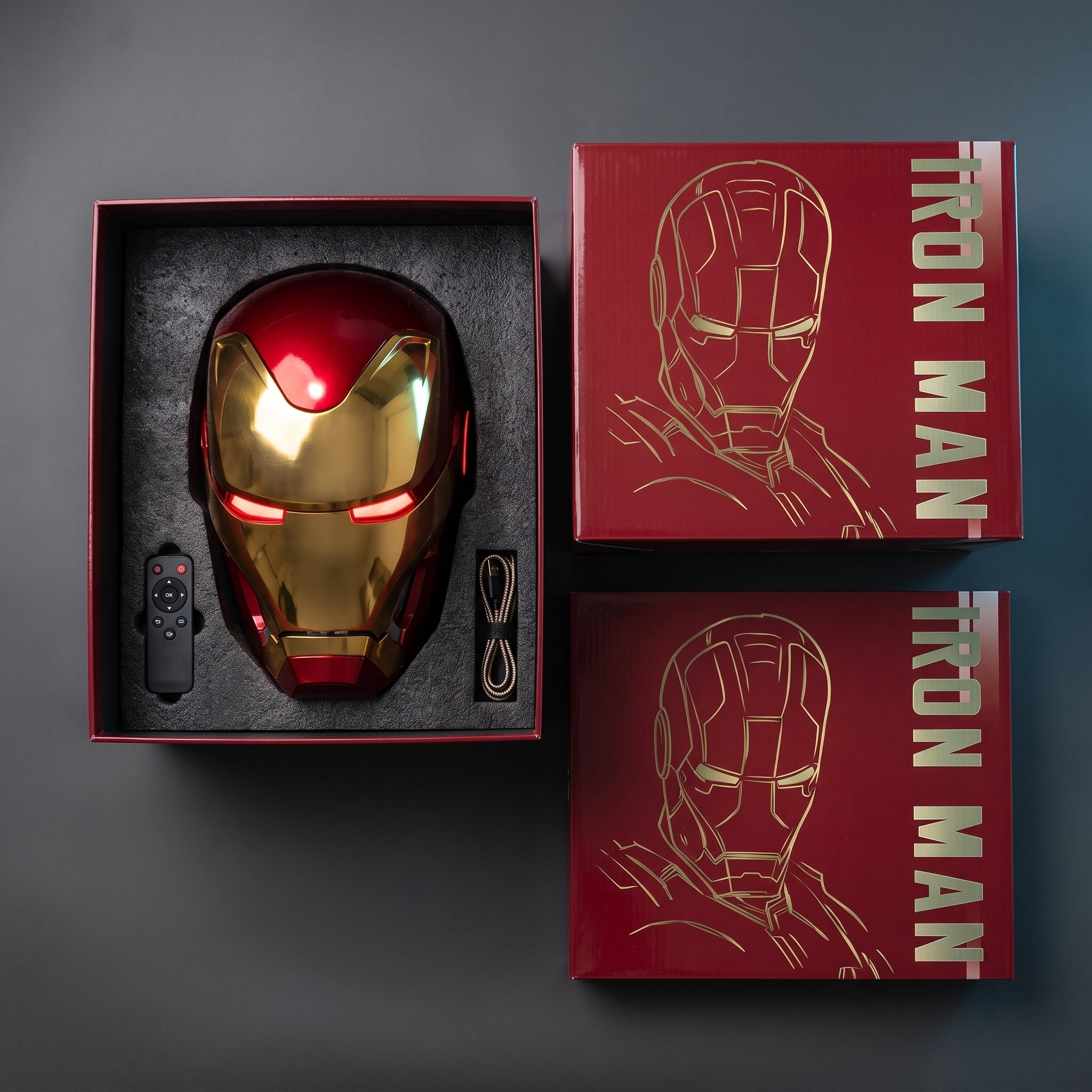 Red and gold Mark L helmet in its open box with remote control and USB charging cable