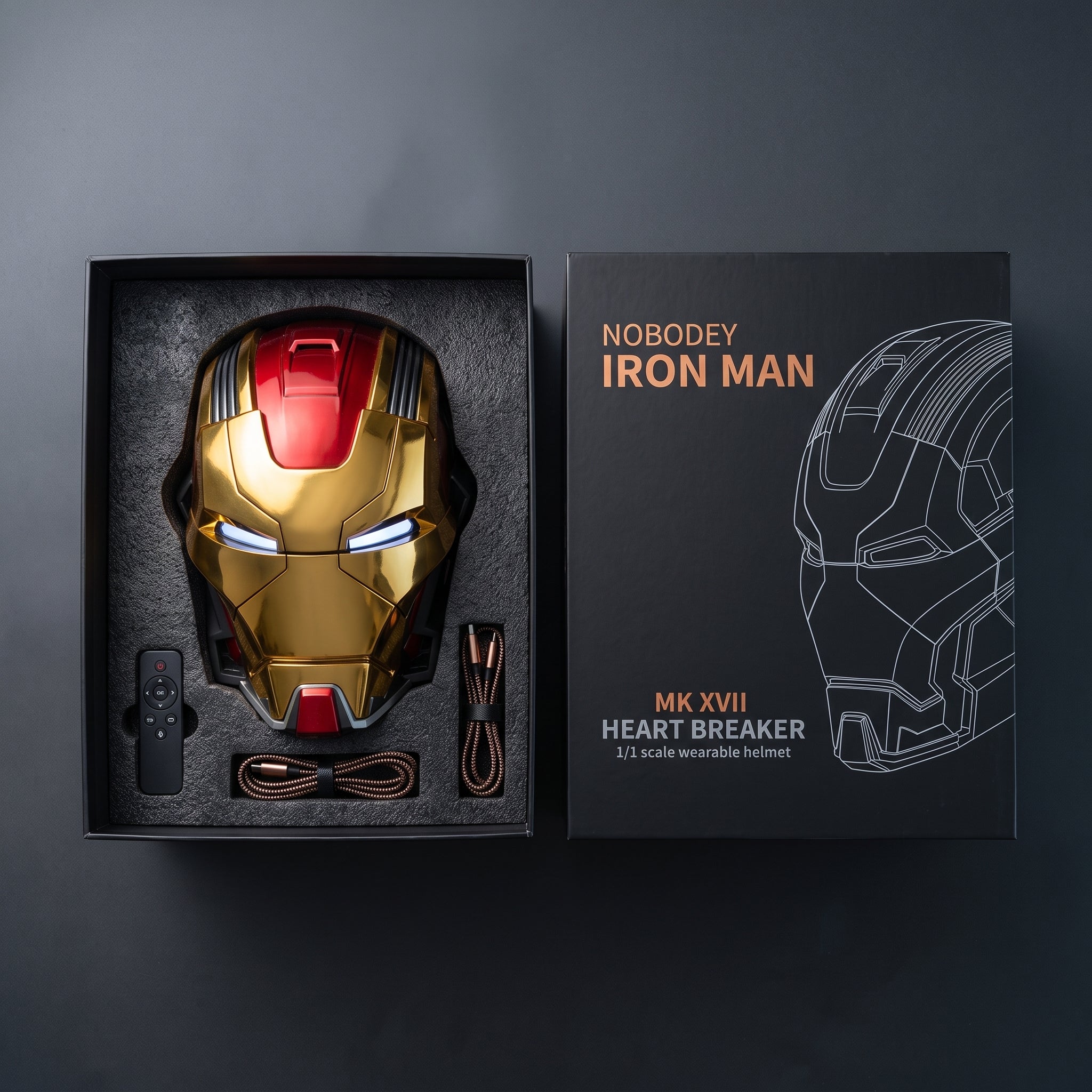 Gold and red Mark XVII helmet in its open box with remote and USB charging cable